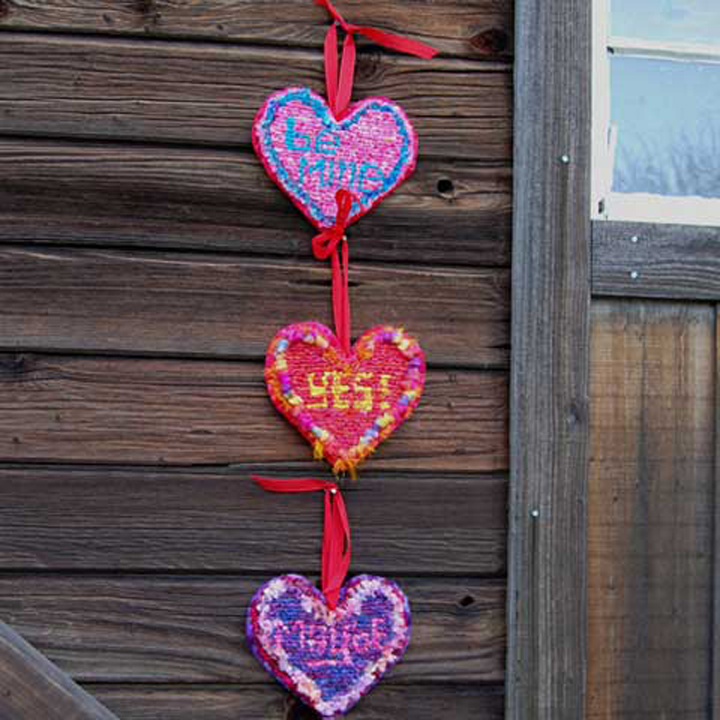 7 ½” W x 7”H - Designs by Theresa PulidoMade with fabric strips, Sari Ribbon Strips, red woven craft ribbon, glitter.